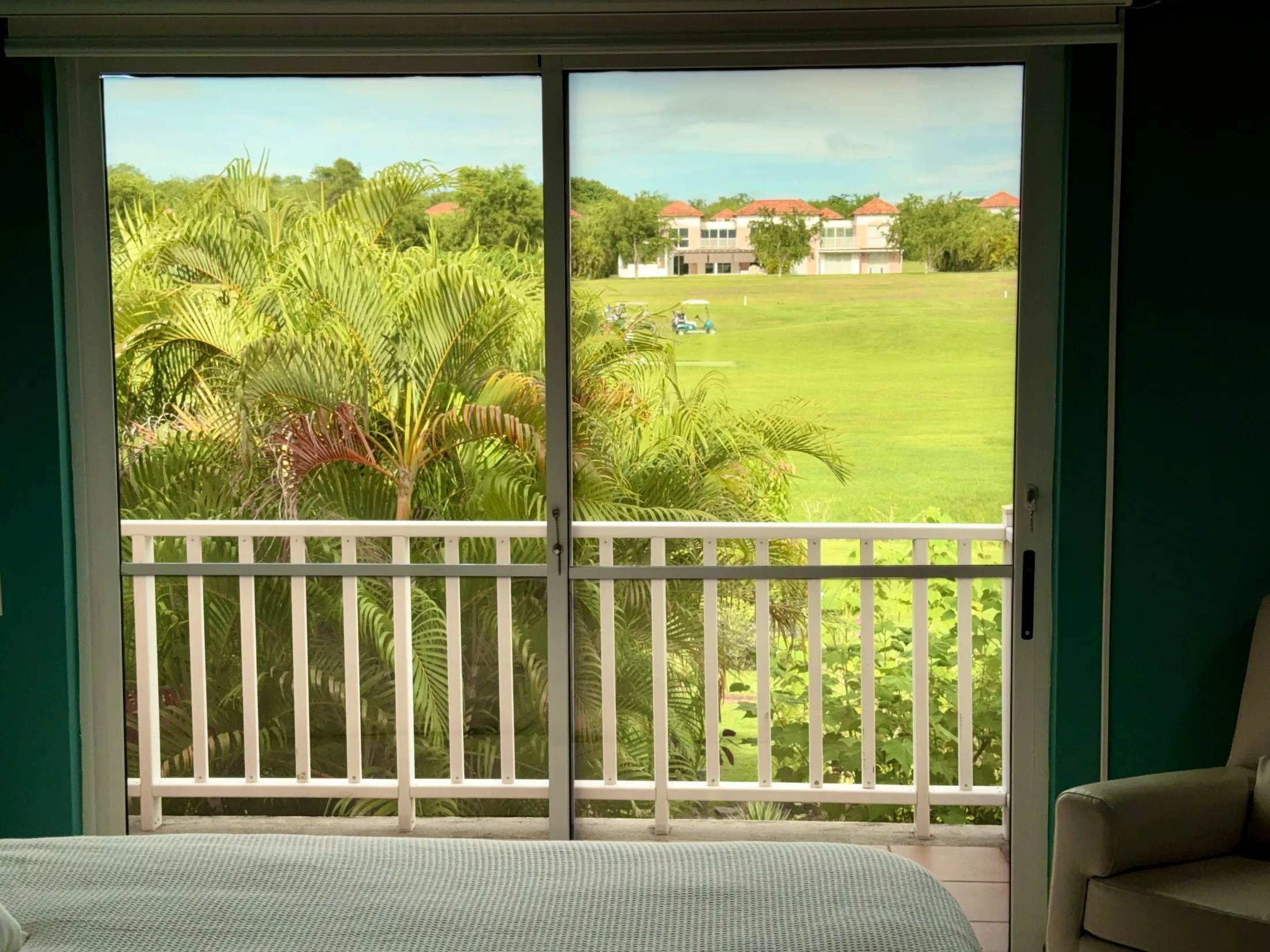 Golf fairway view from teal Bedroom A through balcony sliding doors
