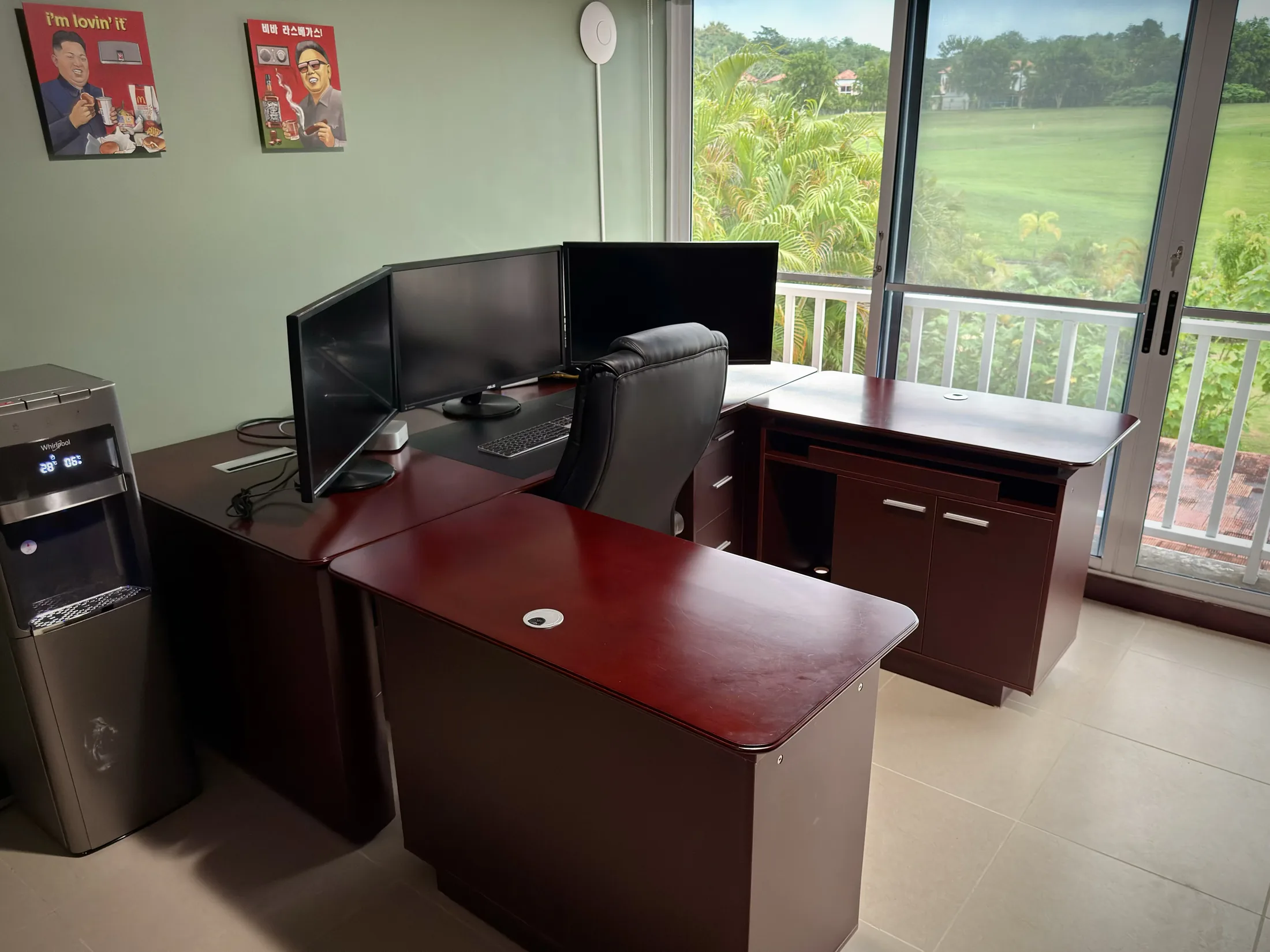 Office desk near large windows with dual monitors and golf-course fairway view