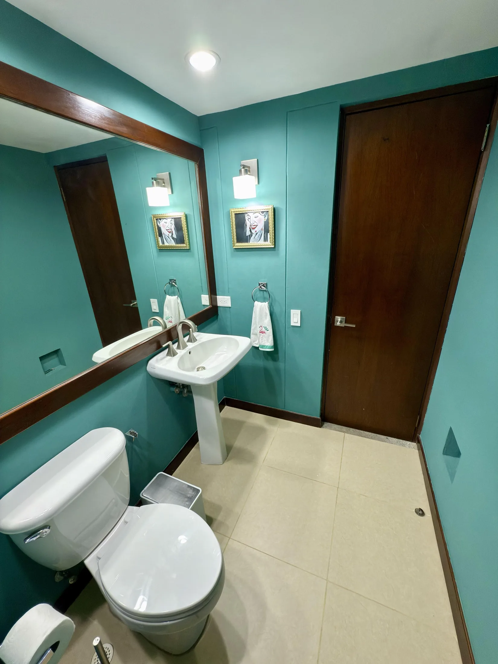 Teal bathroom alternate angle showing pedestal sink, toilet, and doorway