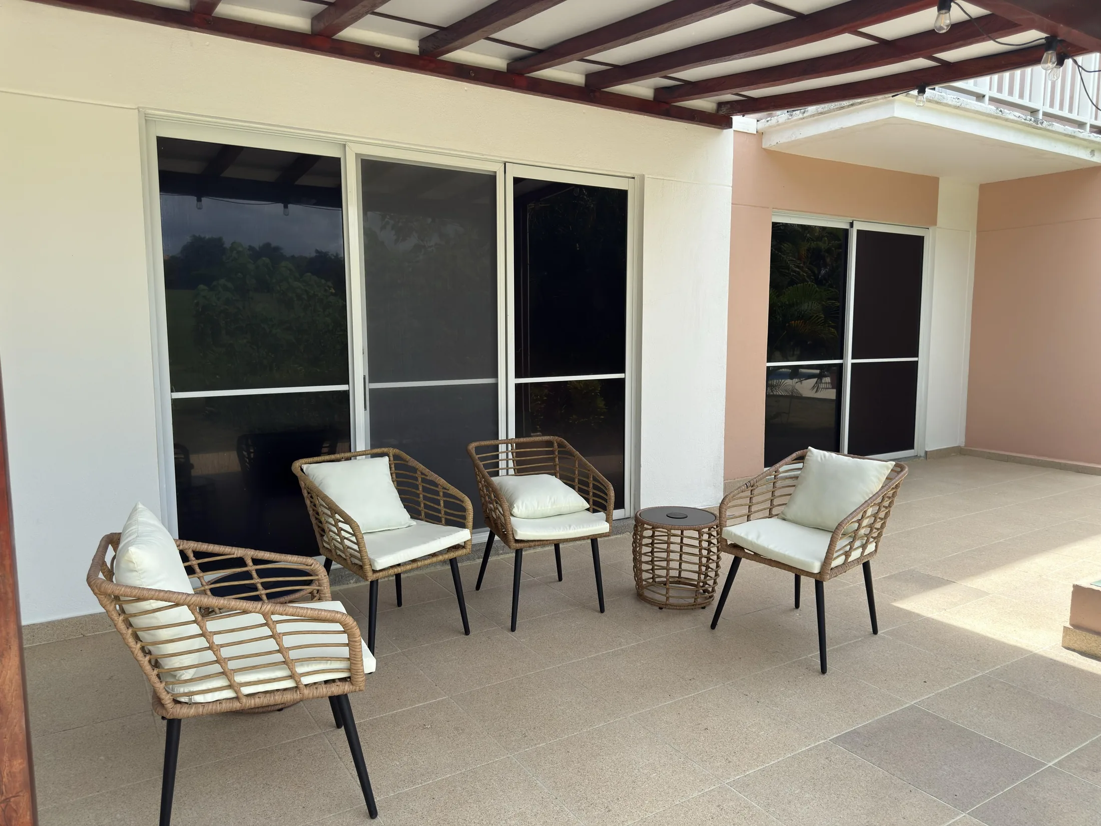 Rear covered patio with wicker seating chairs and sliding glass doors