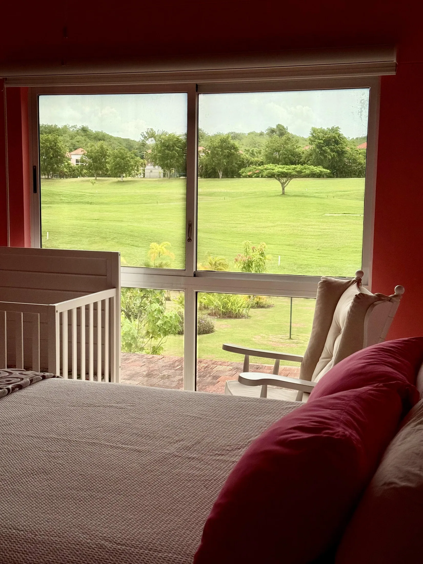 Coral bedroom window close-up with golf-course fairway and patio view